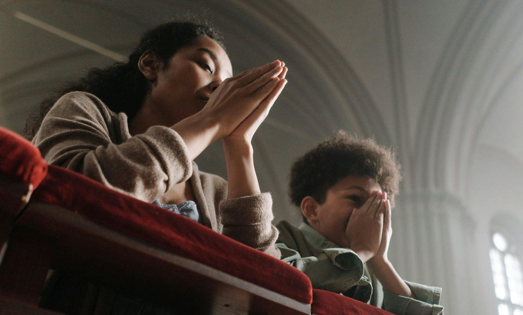two black kids praying in church