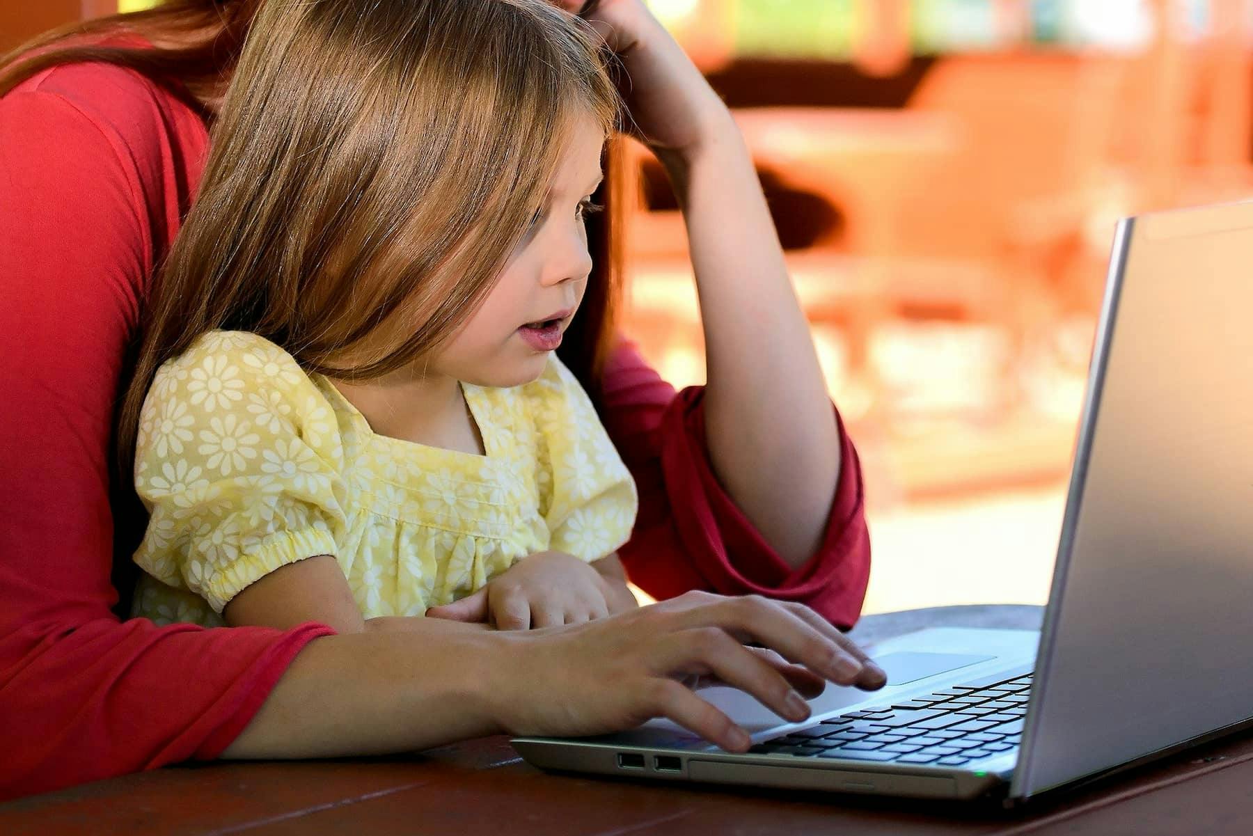 Child studying with her mom on a laptop