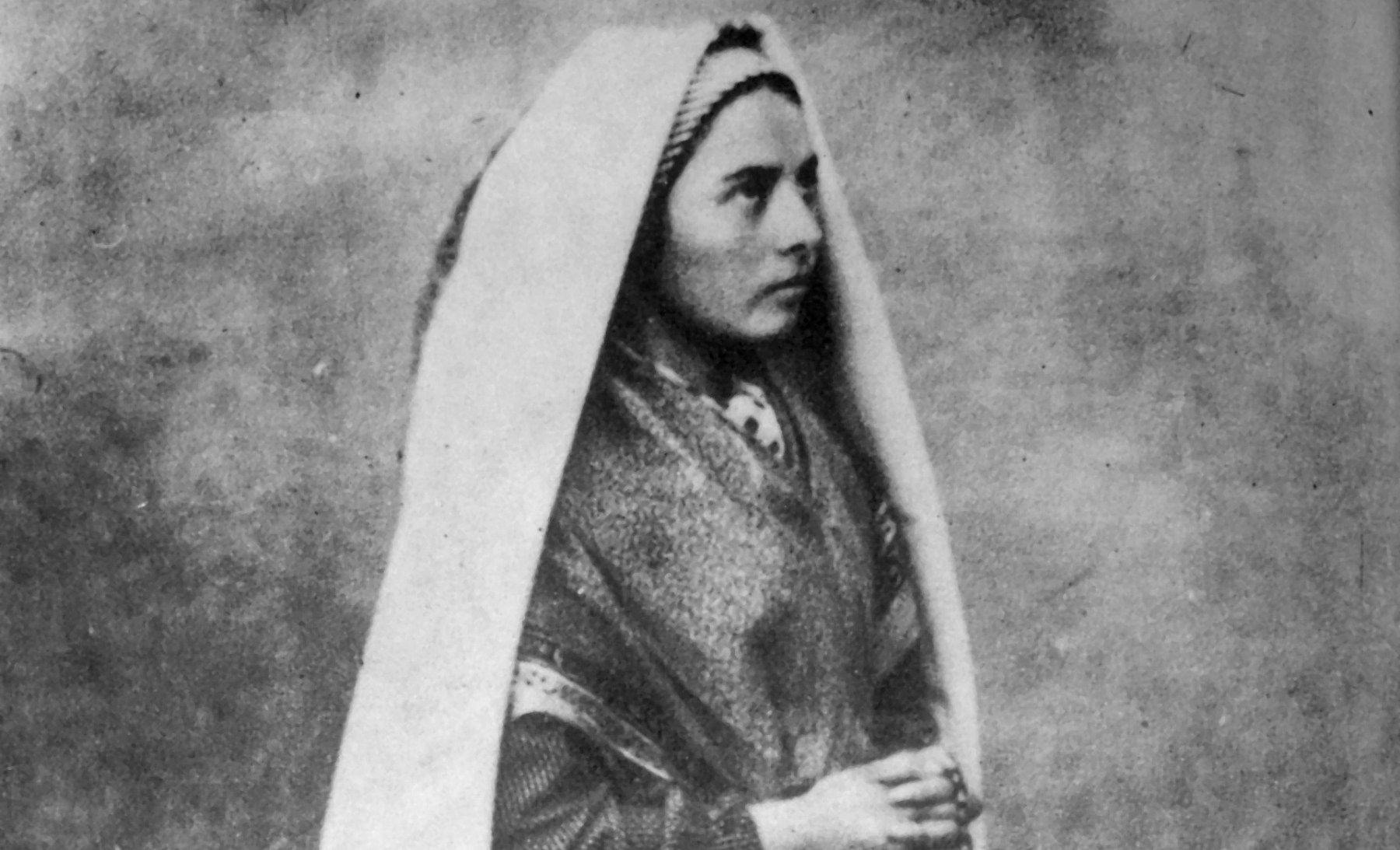 Bernadette Soubirous kneeling with rosary in her hands