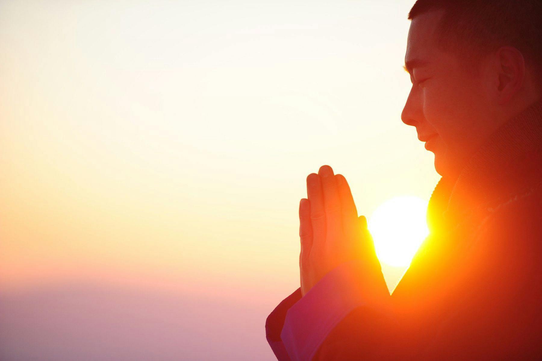 man meditating healing energy sunset
