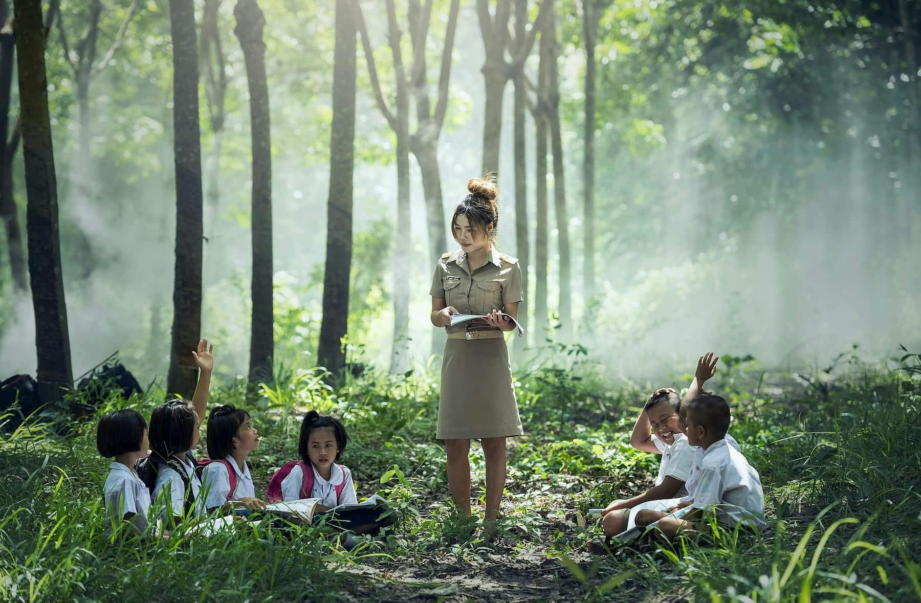 Teacher teaching children in a forest